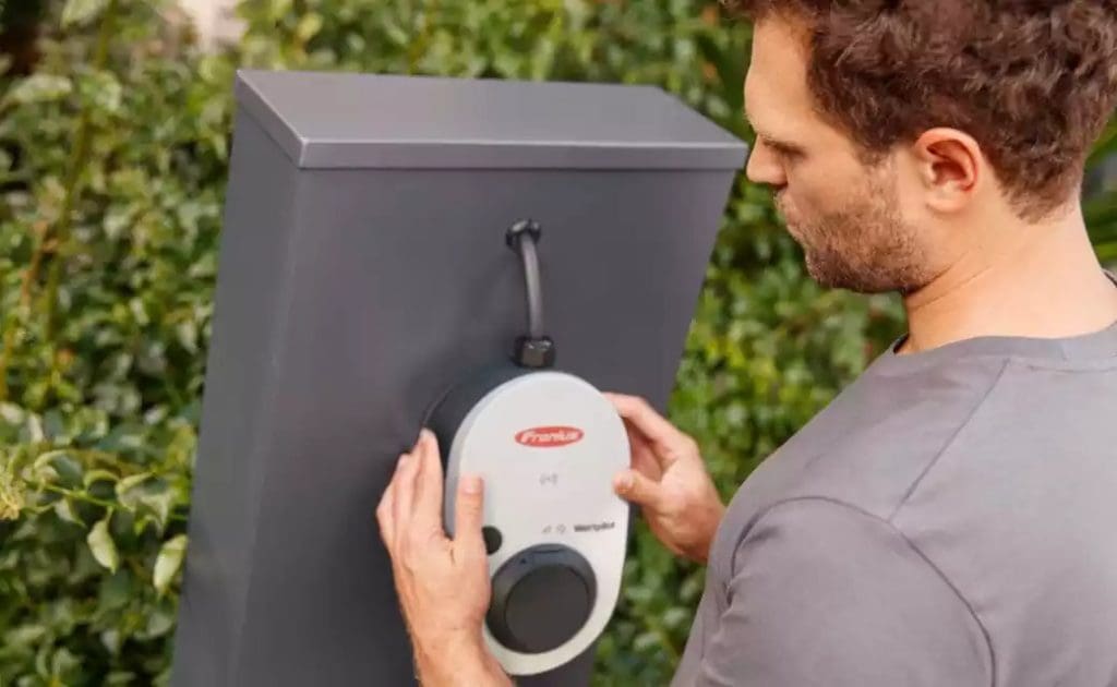 Electrician installing a Fronius wattpilot to a grey mounting box