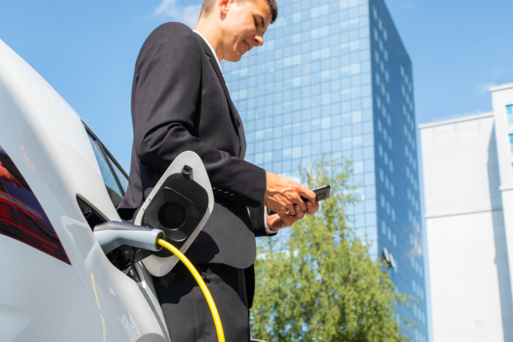 Businessman at an EV charging station