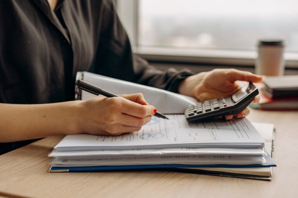 Lady with calculator in hand looking over a power bill